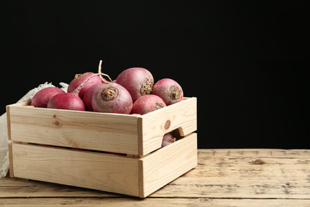 Crate with red turnips on wooden table. Space for textの写真素材