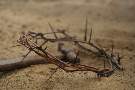 Crown of thorns and hammer on sand. easter attributesの写真素材
