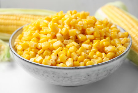 Bowl of preserved corn on white table, closeupの写真素材