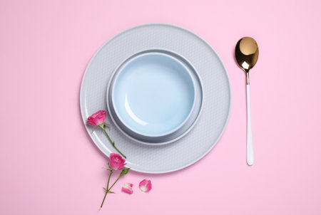 Beautiful table setting with flowers on pink background, flat layの写真素材