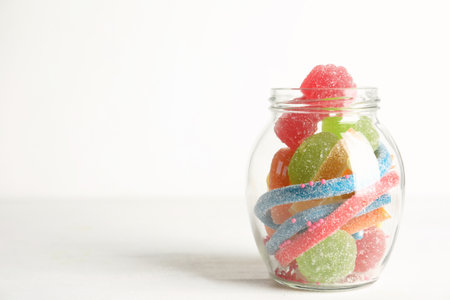 Delicious colorful candies on white table. Space for textの写真素材
