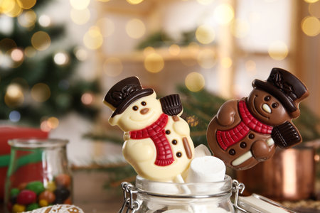 Funny chocolate snowmen candies in glass jar with marshmallows, closeupの写真素材