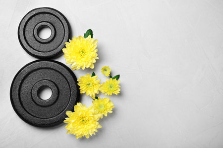 8 March greeting card design with chrysanthemum flowers, weight plates and space for text on light gray background, flat lay. International Women's dayの写真素材