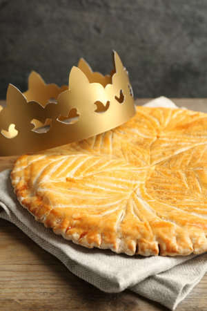 Traditional galette des Rois with paper crown on wooden table, closeupの写真素材