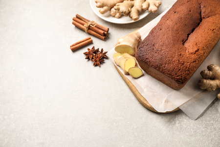 Delicious gingerbread cake and ingredients on light gray table, above view. Space for text