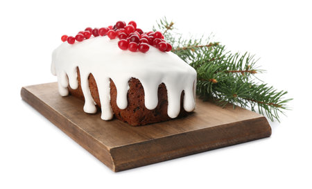 Traditional classic Christmas cake decorated with cranberries near fir tree branch isolated on whiteの写真素材