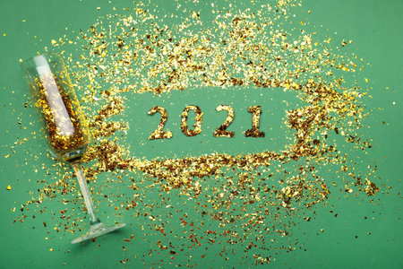 Flat lay composition with confetti and champagne glass on green background. new year celebrationの写真素材