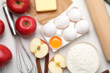 Traditional English apple pie ingredients on white wooden table, flat layの写真素材