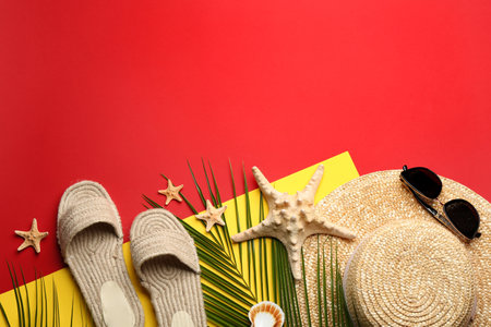 Beach accessories on red background, flat lay. Space for textの写真素材
