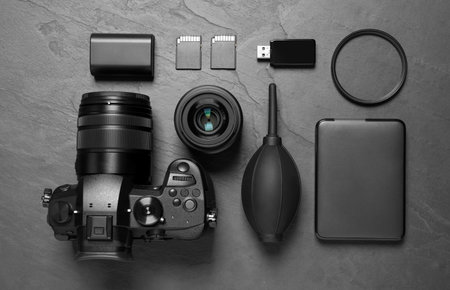 Flat lay composition with camera and video production equipment on gray stone background