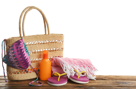 Stylish bag with beach accessories on wooden table. Space for textの写真素材