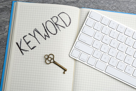 Key, notebook and computer keyboard on table, flat lay. Keyword conceptの写真素材