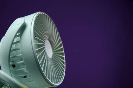 Modern electric fan on violet background, closeup. Space for textの写真素材