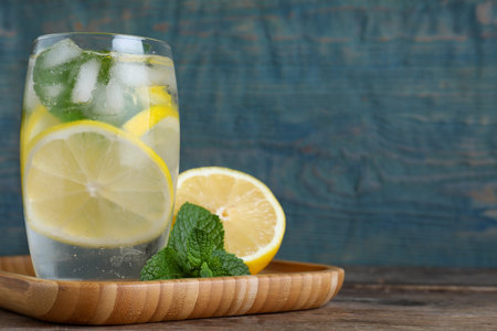 Delicious lemonade made with soda water and fresh ingredients on wooden table against light blue background. Space for textの写真素材