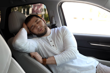 Tired man sleeping in his modern car