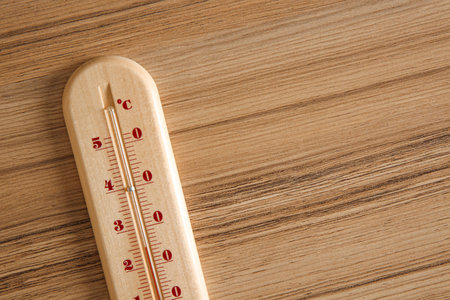 Weather thermometer on wooden table, top view. Space for textの写真素材