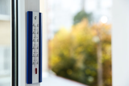 Weather thermometer on window frame indoors. Space for textの写真素材