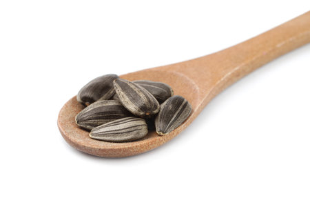 Raw organic sunflower seeds in wooden spoon isolated on whiteの写真素材