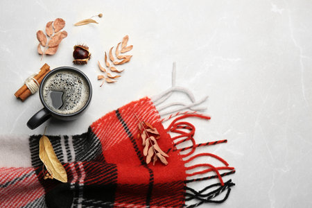 Flat lay composition with hot drink and warm plaid on light marble table, space for textの写真素材