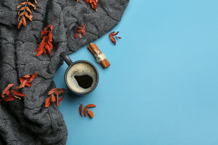 Flat lay composition with hot drink and warm plaid on light blue background, space for textの写真素材