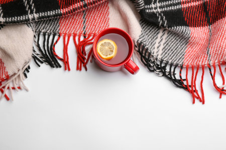 Flat lay composition with tea and warm plaid on white background, space for textの写真素材