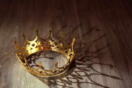 Beautiful golden crown with gems on wooden table. fantasy itemの写真素材