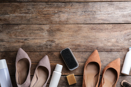 Stylish footwear with shoe care accessories on wooden table, flat lay. Space for textの写真素材