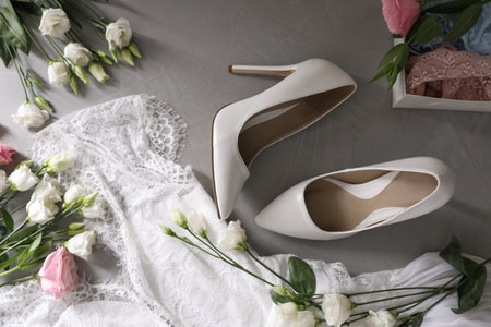 Flat lay composition with wedding dress, white high heel shoes and flowers on gray backgroundの写真素材