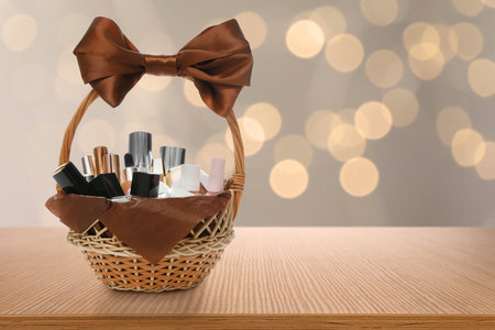 Wicker basket full of cosmetic products on table against blurred festive lights. Space for textの写真素材