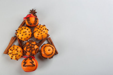 Christmas tree shape made of fresh tangerines and spices on light gray background, flat lay. Space for textの写真素材