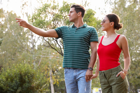 Lovely couple walking together in park on sunny dayの写真素材