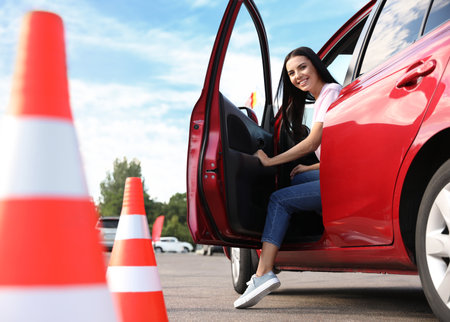 Young woman in car near traffic cones outdoors. driving school examの写真素材