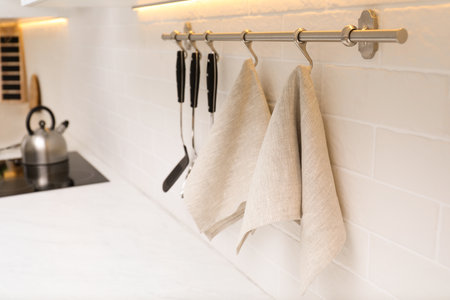 Kitchen utensils and clean towels hanging on wall indoorsの写真素材