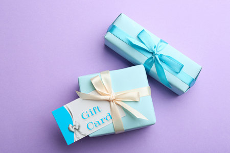 Gift card and presents on violet background, flat layの写真素材