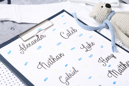 Clipboard with different baby names and toy on child's clothes, closeupの写真素材