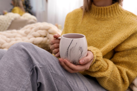 Woman with cup of drink indoors, closeupの写真素材