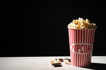 Delicious popcorn and tape on table. Space for textの写真素材