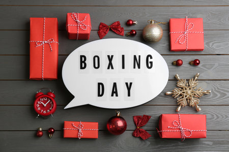 Flat lay composition with Boxing Day sign and Christmas gifts on gray wooden tableの写真素材