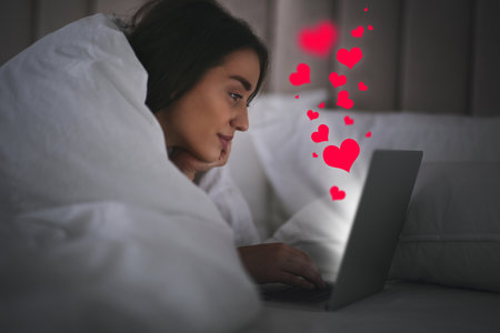 Young woman dating visiting site via laptop indoorsの写真素材