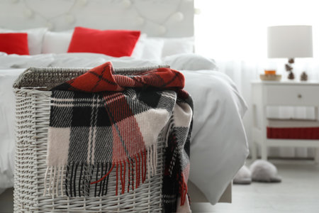 Wicker basket with warm checkered plaid in the bedroomの写真素材