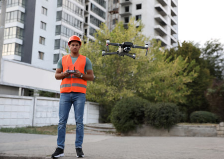 Builder operating drone with remote control at construction site. aerial photographyの写真素材