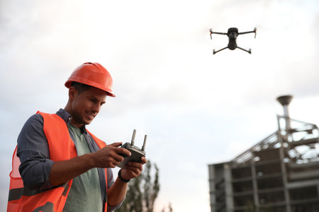 Builder operating drone with remote control at construction site. aerial photographyの写真素材