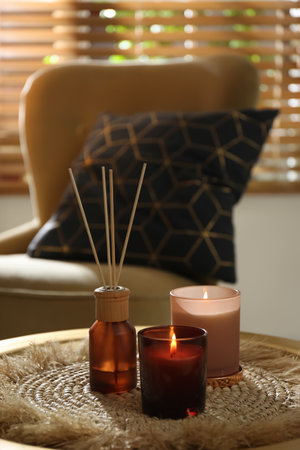 Air reed freshener and candles on table in roomの写真素材