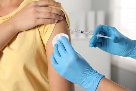 Doctor giving injection to patient in hospital, closeup. Vaccination dayの写真素材
