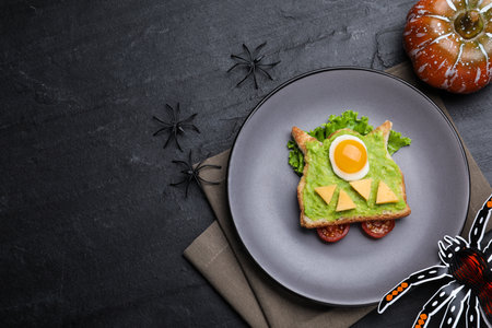Halloween themed breakfast served on black table, flat lay and space for text. Tasty sandwich with fried eggの写真素材