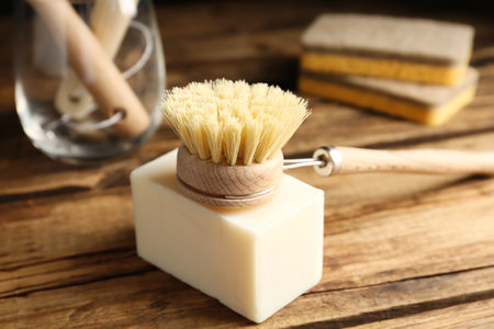 Cleaning brush and soap bar for dish washing on wooden table, closeupの写真素材