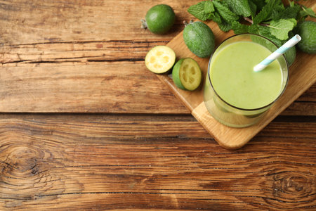 Fresh feijoa smoothie and ingredients on wooden table, flat lay. Space for textの写真素材