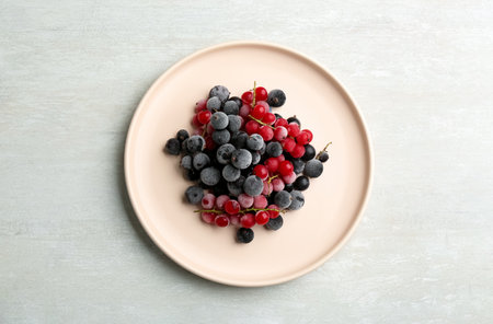 Tasty frozen red and black currants on white table, top viewの写真素材