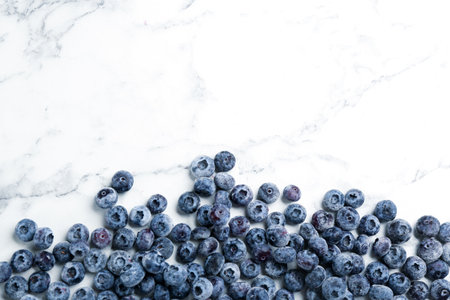 Tasty frozen blueberries on white marble table, flat lay. Space for textの写真素材