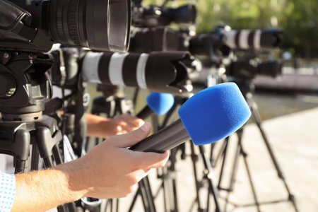 Journalists with microphones and video cameras outdoors, closeupの写真素材
